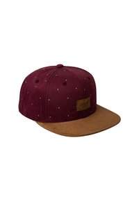 Gorra snapback burdeos con visera de ante marrón, que presenta pequeños puntos blancos y una etiqueta rectangular marrón en la parte frontal.