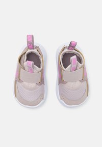 Vaaleanpunaiset urheilukengät, joissa on verkkokangas- ja nahkamateriaaleja, tarrasuljin, valkoinen pohja ja vetolenkki kantapäässä.