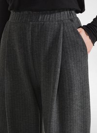 Grijze gestreepte broek met een elastische tailleband, voorzien van zijzakken, een relaxte pasvorm en een zachte, wolachtige textuur.
