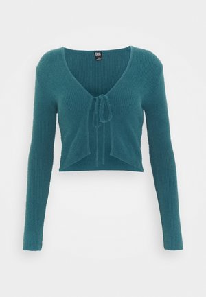 Tiefgrüne, kurz geschnittene Strickjacke aus strukturiertem Material mit langen Ärmeln und Bindeband vorne, ausgestattet mit einem tiefen V-Ausschnitt.