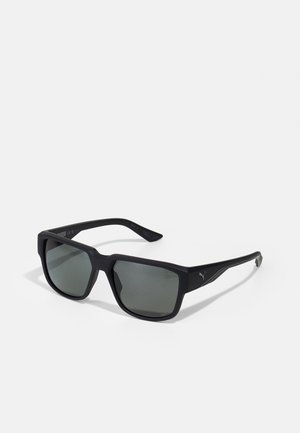 Ochelari de soare negri în formă de pătrat, cu lentile gri. Fabricati din plastic mat, având un design minimalist și accente subtile cu logo pe brațe.