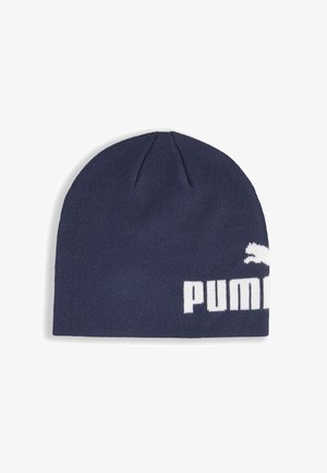 Marineblauwe gebreide beanie met witte Puma-tekst en -logo die gedeeltelijk zichtbaar zijn aan de rechteronderkant, tegen een witte achtergrond.