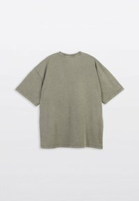 Olivegreenowy, oversize t-shirt z krótkimi rękawami, okrągłym dekoltem i widocznymi detalami szycia na teksturowanej bawełnianej tkaninie.