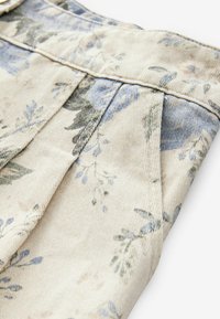 Beige värviline kangas siniste ja roheliste detailidega. Omab voldikesi ja tekstureeritud pinda, sobib riiete või aksessuaaride valmistamiseks.