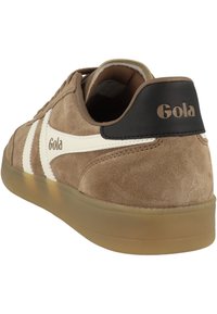 Baskets en daim marron Gola avec des rayures blanches sur les côtés, semelle en gomme et languette de talon noire arborant le logo Gola en lettres beige.