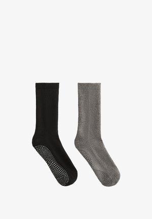 Fekete és szürke bordázott zoknik csúszásgátló pontozott talppal. Minden zokni középmagas, a vádli közepéig ér, és puha tapintású.