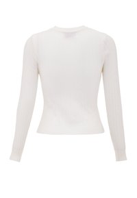 Top a maniche lunghe bianco a costine, caratterizzato da una silhouette aderente, scollatura rotonda e una texture sottile. Sul retro presenta una piccola apertura vicino al collo.