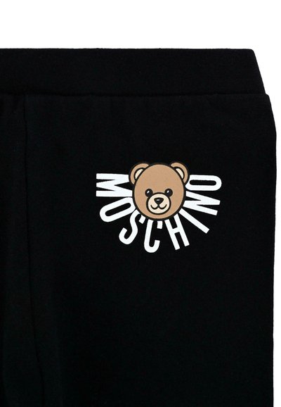 Czarne dresy z grafikiem brązowego niedźwiedzia i napisem "MOSCHINO". Projekt wyróżnia się gładką fakturą i wyraźnym białym napisem.