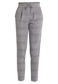 Pantalons slim taille haute avec un motif à carreaux noir et blanc, ceinture élastique et cordon de serrage.