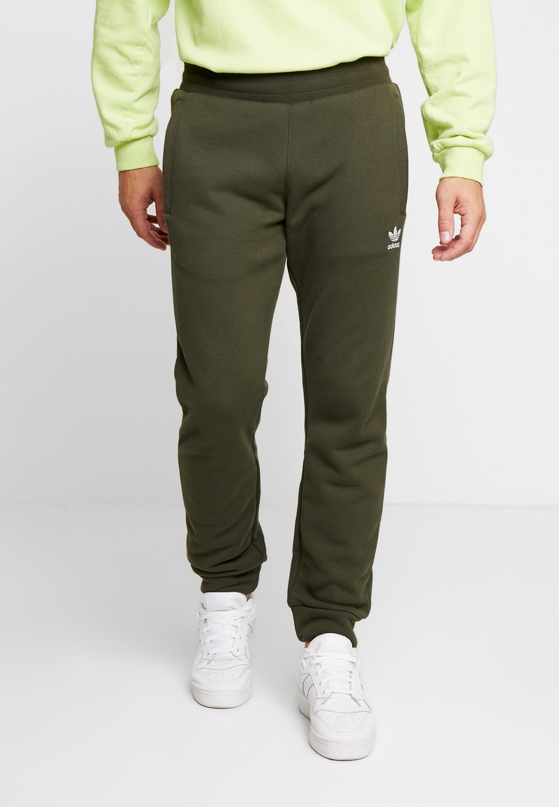 Mörkgröna sweatpants med smal passform, med sidfickor och en liten vit logotyp. Kombineras med vita sneakers. Slät tygkänsla.