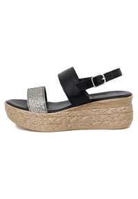 Sandali wedges neri con una fascia larga e texturizzata in glitter e una cinghia alla caviglia regolabile. La base rivestita in juta aggiunge una texture naturale.