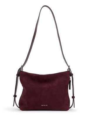 Sac bandoulière en daim bordeaux foncé avec longue sangle réglable et petit logo "nat & nin" au centre devant.