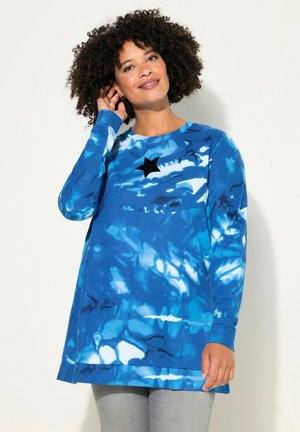 Maglietta a maniche lunghe blu tie-dye con un accento a forma di stella nera sul petto, dal taglio rilassato e orlo arrotondato. Realizzata in morbido cotone.