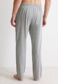 Grijze pyjamabroek met een elastische tailleband, rechte pijpen en zijzakken, gemaakt van een zachte katoenmix. Geen zichtbare patronen.