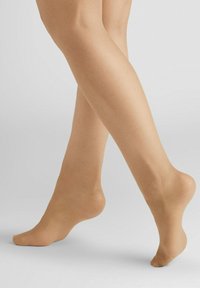 Nude tights on bare legs, showcasing a smooth, matte texture, with a natural skin tone appearance and a slightly sheer finish.