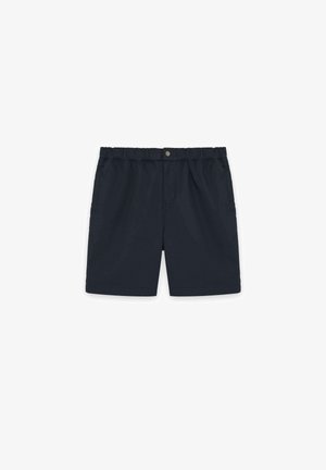 Shorts bleu marine à taille élastique avec fermeture à bouton-pression et poches latérales, posés à plat sur un fond blanc.