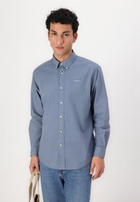 Cămașă cu butoni în albastru deschis din bumbac, cu mâneci lungi, guler cu butoni și logo-ul subtil "Barbour" brodat pe piept.