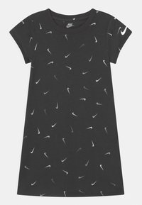Czarna sukienka z krótkim rękawem z rozproszonym wzorem białych i szarych logo Nike. Wykonana z miękkiego, lekkiego materiału.