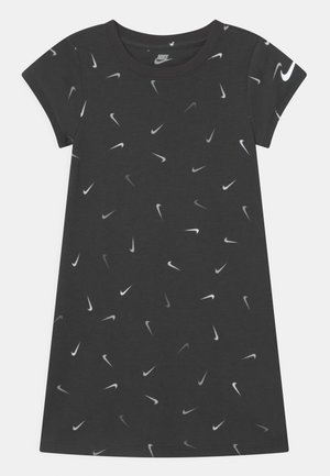 Schwarzes Kurzarmkleid mit einem verstreuten Muster von weißen und grauen Nike-Swoosh-Logos. Hergestellt aus einem weichen, leichten Stoff.