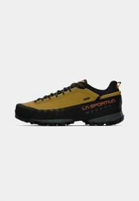 Shoe de caminhada de corte baixo da La Sportiva, amarelo e preto, com atacadores pretos, marcação laranja e sola robusta em fundo branco.