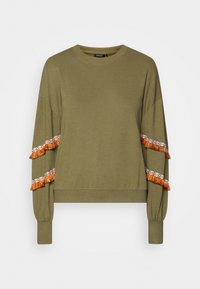 Sudadera verde oliva con hombros caídos, con acentos de borlas naranjas y blancas en las mangas. Material de algodón suave, con un corte cropped.