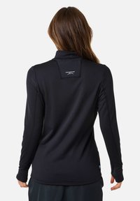 Mustahiilaga musta pikka varrukaga särk, millel on kõrge kaelus, ribakonstruktsioon ja logo seljal. Omab kohandatud disaini ja sildid detaili hemil.