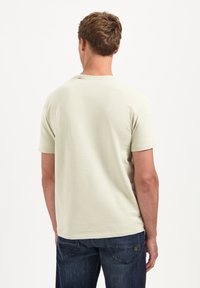Lichtgroene, T-shirt met korte mouwen en een gestructureerd gestreept patroon, ronde halslijn en een normale pasvorm, gecombineerd met donkerblauwe denim jeans.