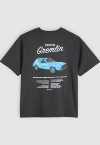 Μαύρο T-shirt με μπλε vintage αυτοκίνητο εικονογραφημένο και λευκό κείμενο "DENIM Gremlin" καθώς και προωθητικές λεπτομέρειες για το αυτοκίνητο στο πίσω μέρος.