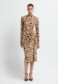 Abito a maniche lunghe con stampa leopardata in beige e marrone, caratterizzato da un collo alto e arricciamenti laterali, abbinato a décolleté burgundy a punta.