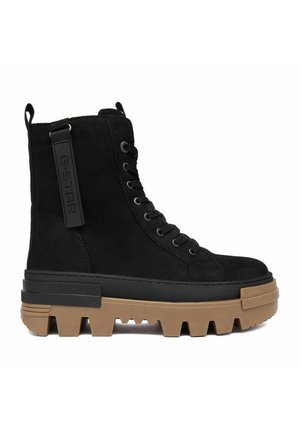 Schwarzer hoher Schnürstiefel mit dicker brauner grober Sohle und G-Star-Label an der Seite.