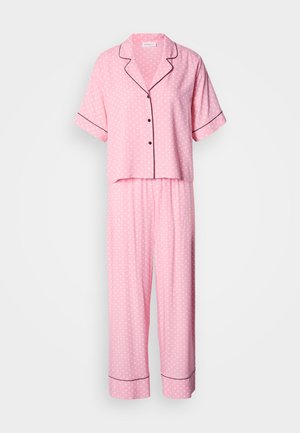 Roosa täpiline pidžaamasett, lühikeste varrukatega nööpidega särk ja elastse vöökohaga püksid; äärte ümber on musta torustikku.