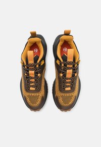 Black and yellow athletic shoes with a textured mesh upper, padded collar, and reinforced toe. Features contrast laces and a bright logo.
