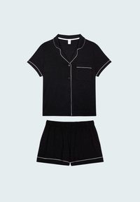 Czarny komplet piżamowy z krótkim rękawem, wykonany z miękkiego materiału, z białym obszyciem na kołnierzyku, kieszeni i dolnej części szortów. Elastyczny pas w szortach.