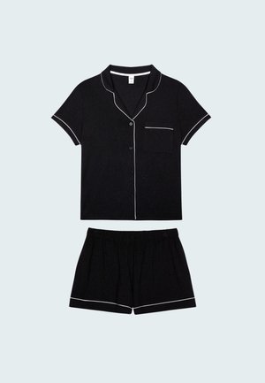 Schwarzes Kurzarm-Schlafanzug-Set aus weichem Stoff, mit weißen Paspeln am Kragen, an der Tasche und am Saum der Shorts. Elastischer Bund an den Shorts.