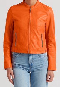 Giacca in pelle arancione con colletto alto, chiusura frontale con cerniera e due tasche laterali con zip. Caratterizzata da un design aderente e una texture liscia.