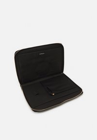 Housse d'ordinateur portable noire avec fermeture éclair, présentant un extérieur lisse, une poche intérieure et des détails de fermeture éclair dorée. Construction en tissu léger.