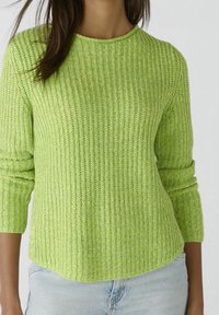 Grøn ribbet sweater med lange ærmer, rund halsudskæring og en afslappet pasform. Teksturen er strikket med en subtil variation i farven.