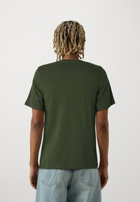 Dark green short-sleeve t-shirt made of smooth fabric, featuring a classic crew neck and a relaxed fit, with a plain back design.