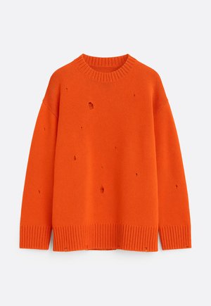 Pull tricoté orange vif à col ras du cou, avec poignets et ourlet côtelés, présentant plusieurs petits trous intentionnels comme un design usé.