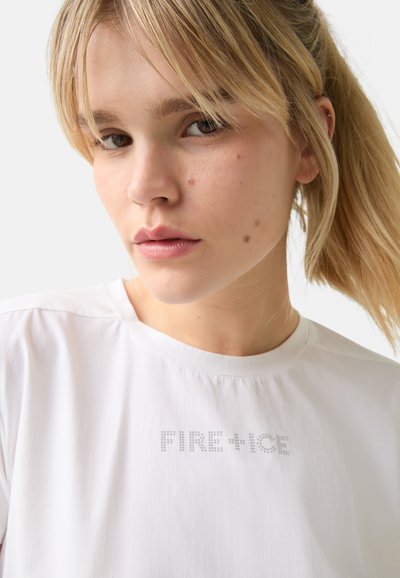 Bílá košile s krátkým rukávem, která má texturovaný vzor a na přední straně nápis "FIRE+ICE" vyjímaný malými tečkami. Jednoduchý výstřih, ležérní design.