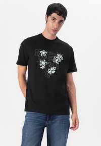 Black cotton t-shirt featuring a triangular floral graphic design, with white and light blue accents, and short sleeves.