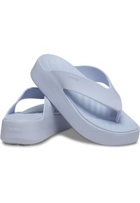 Tongs bleu clair en matériau doux et flexible avec une semelle épaisse, présentant un design minimaliste et des bandes à deux brides.