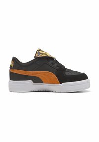 Sneaker bas noir avec une bande en daim orange, semelle blanche et détail en imprimé animal sur la languette, présenté de côté sur fond blanc.