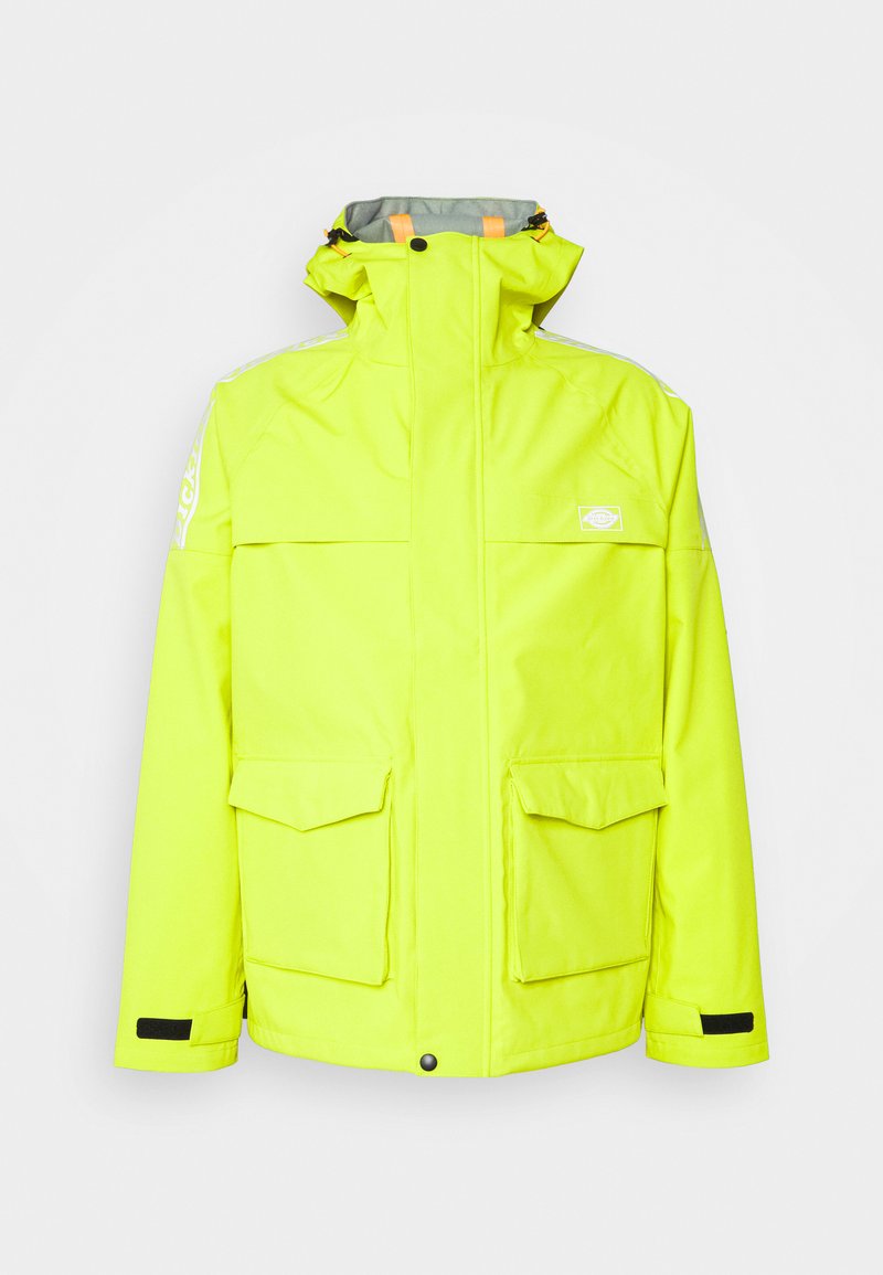 Giacca impermeabile gialla brillante con colletto alto, numerose tasche e foderatura interna grigia e arancione. Presenta accenti riflettenti.