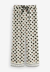 Pantaloni din țesătură albă cu un model repetitiv de cercuri negre, buze roz mici și accente. Prezintă un tiv elastic la talie și șnur.