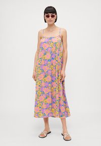 Lightweight floral dress with spaghetti straps. Features a vibrant mix of pink, purple, and yellow flowers on a light background.