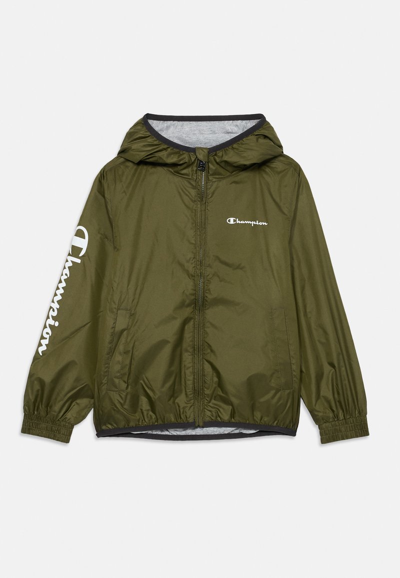 Chaqueta ligera de color verde oliva con capucha, puños elásticos y cierre de cremallera. Presenta un logo blanco de "Champion" en el pecho izquierdo y en la manga.