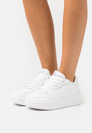 Sneaker bianchi in pelle liscia, con punta arrotondata, suola in gomma spessa e design con lacci, caratterizzati da perforazioni e un marchio discreto.
