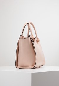Borsa a tracolla in pelle rosa con una superficie liscia, forma curva, doppi manici e bordi neri a contrasto, con un accento annodato su un lato.