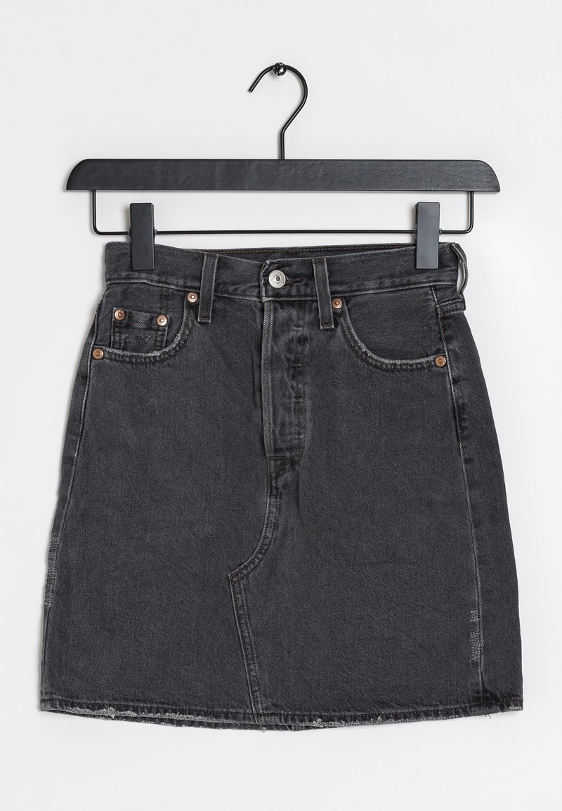 Jupe en denim noir avec poches avant et fermeture par boutons, suspendue sur un cintre noir sur fond blanc.